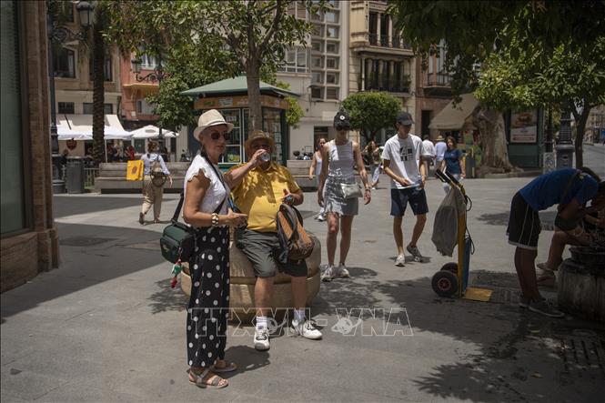 Người dân uống nước giải khát tránh nóng tại Seville, Tây Ban Nha, ngày 12/7/2022. Ảnh minh họa: AFP/TTXVN