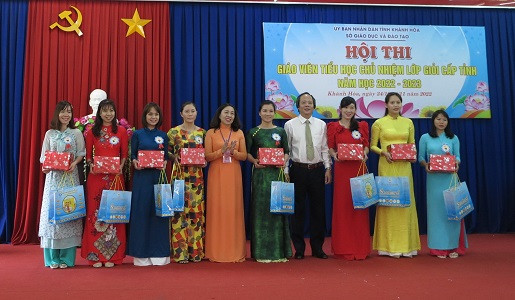 Ông Đỗ Hữu Quỳnh - Phó Giám đốc Sở Giáo dục và Đào tạo Khánh Hòa và bà Trương Minh Hà - Chủ tịch Công đoàn ngành Giáo dục tỉnh Khánh Hòa trao quà cho đại diện các giáo viên của 8 phòng giáo dục và đào tạo. 