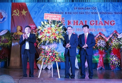 Ông Y Thông (bên trái) tặng hoa chúc mừng Trường Dự bị Đại học Dân tộc Trung ương Nha Trang nhân dịp khai giảng. 