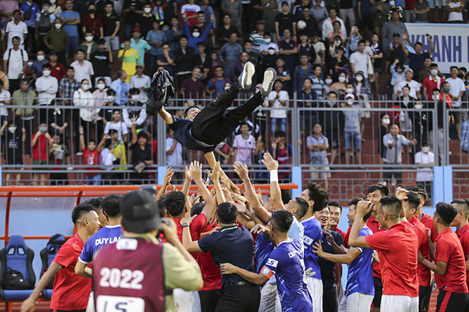 Khanh Hoa FC’s head coach Vo Dinh Tan is thrown into the air by his players after clinching promotion