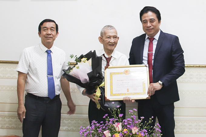 Ông Nguyễn Khắc Toàn trao Huy hiệu 75 năm tuổi Đảng cho đảng viên Hà Văn Cam.