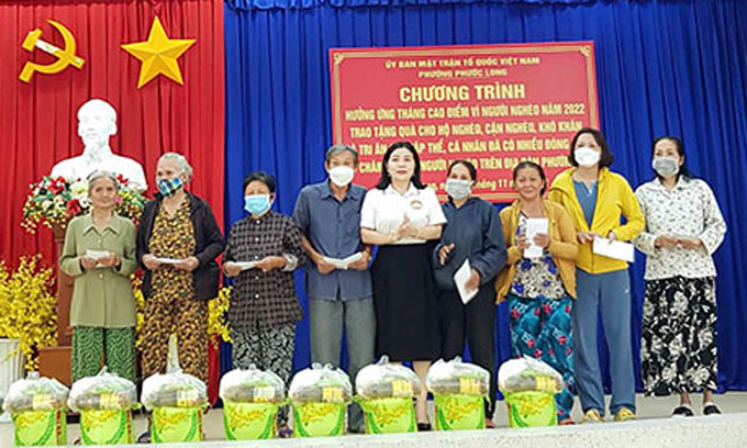 Bà Thái Thị Hương - Chủ tịch UBMTTQ Việt Nam phường Phước Long trao quà cho các gia đình.