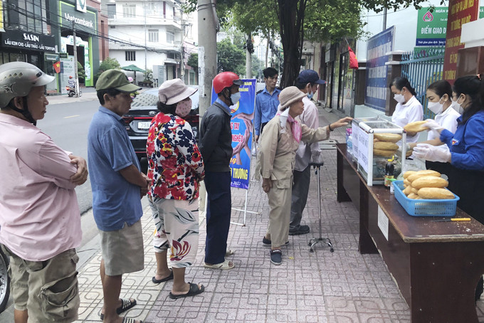 Người dân xếp hàng nhận bánh mì.