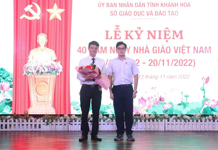 Em Nguyễn Đức Hiệp - Trường THPT Lý Tự Trọng (Nha Trang) đại diện học sinh tặng hoa cho ông Nguyễn Đức Sơn - Phó Giám đốc Sở Giáo dục và Đào tạo. 