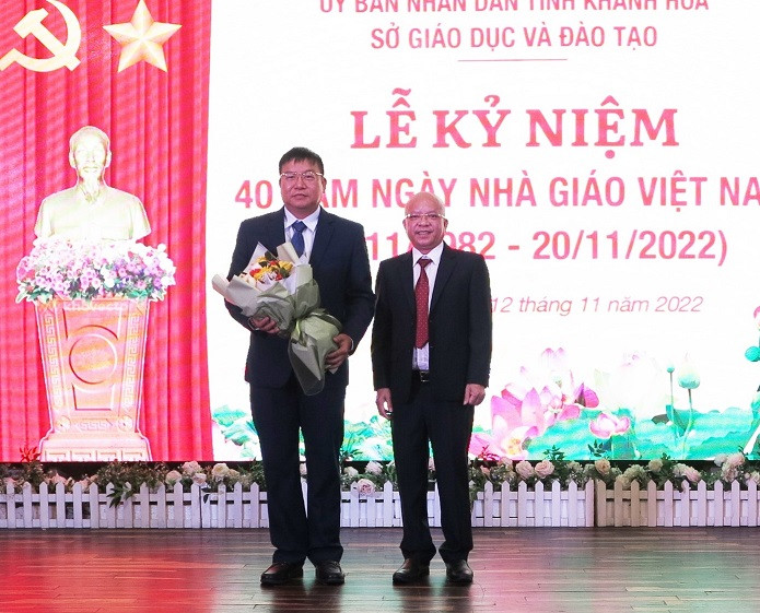 Ông Võ Xuân Hồng - Đại diện phụ huynh học sinh tặng hoa cho ông Võ Hoàn Hải - Giám đốc Sở GD-ĐT. 