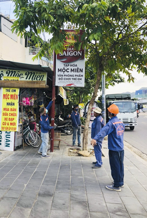Lực lượng chức năng của phường Phước Long tháo dỡ  các bảng quảng cáo vi phạm mỹ quan đô thị ở đường Thích Quảng Đức.