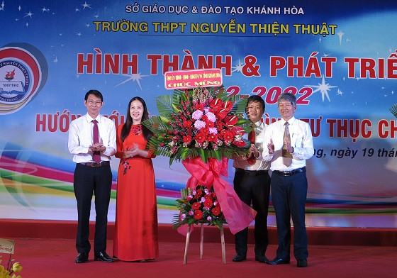 Ông Đinh Văn Thiệu tặng hoa chúc mừng nhà trường. 