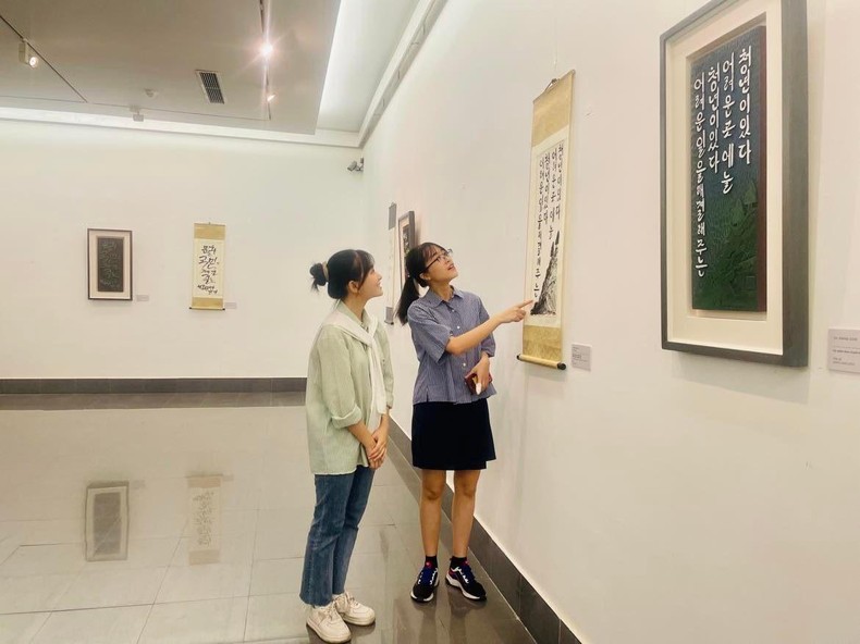 Các bạn trẻ chiêm ngưỡng những tác phẩm thư pháp thể hiện danh ngôn của Chủ tịch Hồ Chí Minh được trưng bày tại triển lãm.