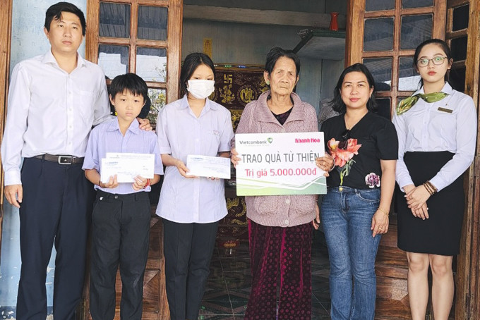 Đại diện Báo Khánh Hòa và Vietcombank Nha Trang  trao tiền ủng hộ cho gia đình có hai cháu Trâm Anh và Gia Huy.