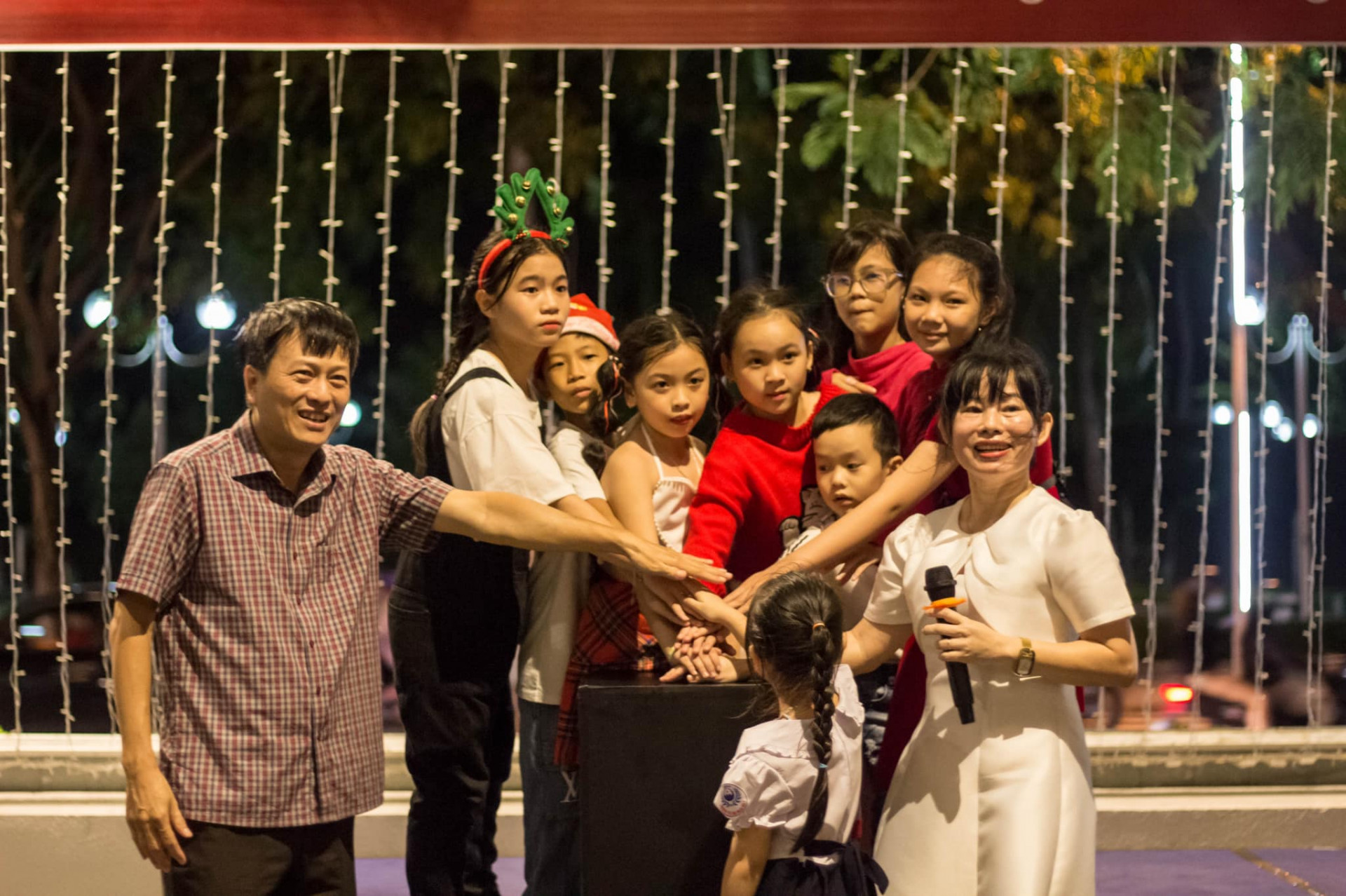 Lãnh đạo khách sạn Novotel Nha Trang và các em thiếu nhi bấm nút thắp sáng cây thông Noel