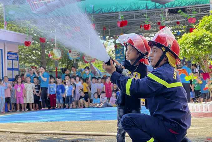  Các bé Trường Mầm non Bình Minh (thị trấn Vạn Giã, huyện Vạn Ninh) thực hành với lăng chữa cháy.