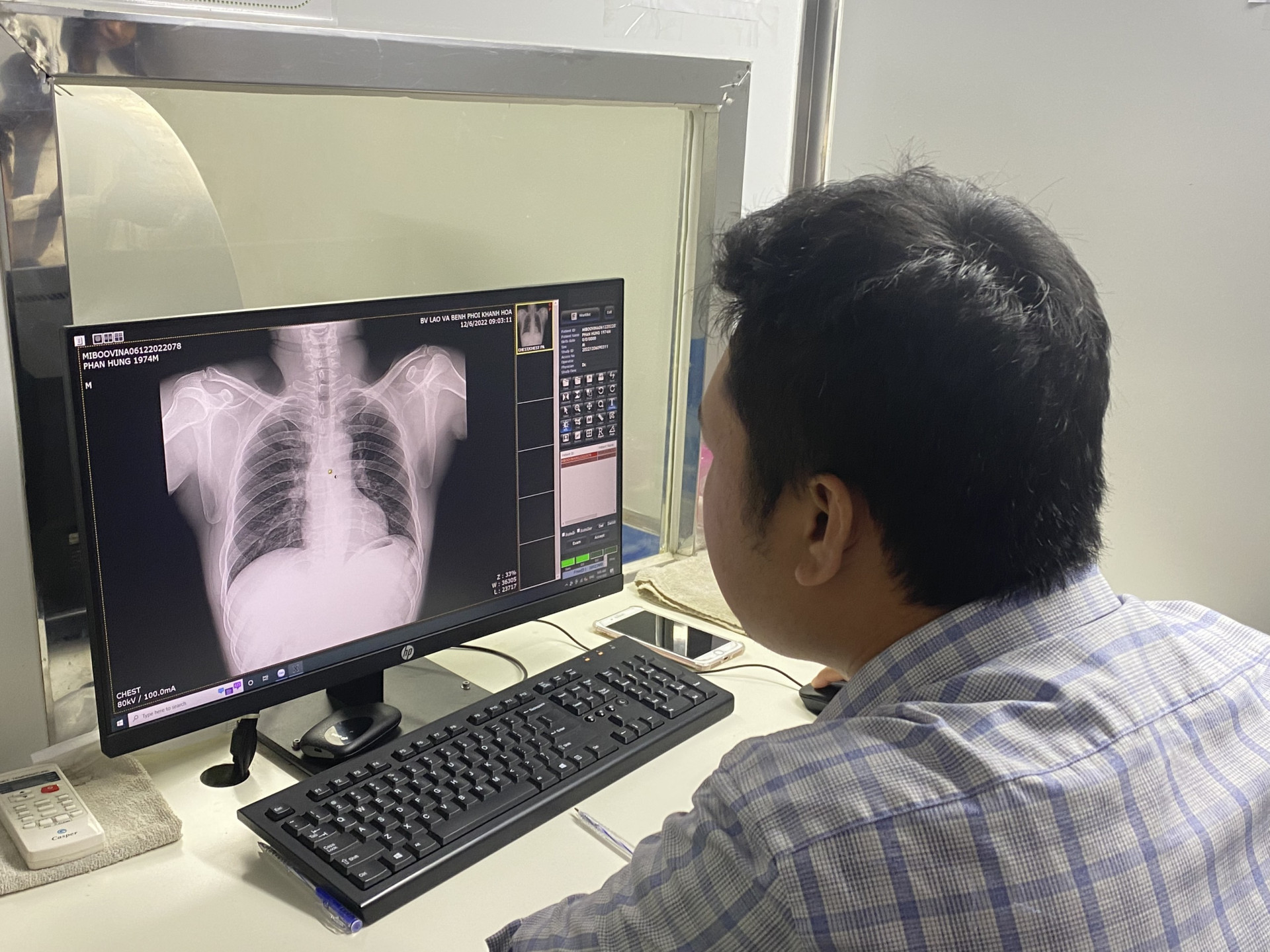 Các y bác sĩ xem kết quả chụp X-quang phổi của công nhân.