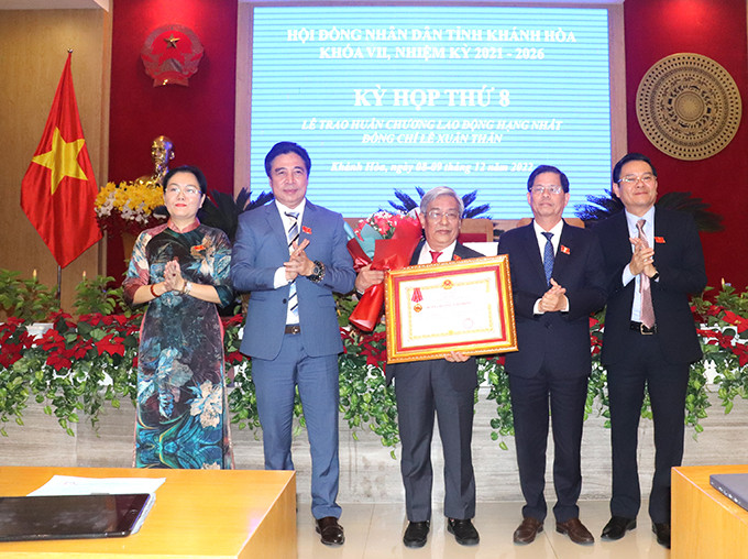 Thừa ủy quyền của Chủ tịch nước, đồng chí Nguyễn Tấn Tuân trao Huân chương Lao động hạng Nhất cho ông Lê Xuân Thân.