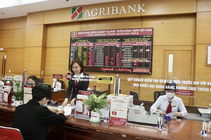 Cán bộ Agribank Khánh Hòa hỗ trợ tư vấn dịch vụ tài chính cho khách hàng.