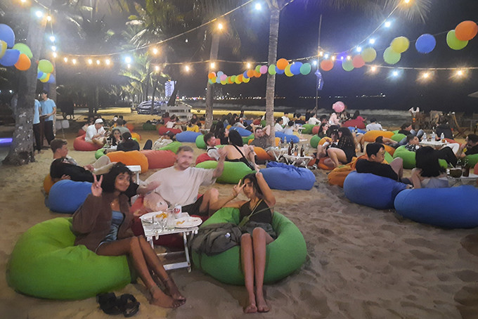 Foreign tourists relaxing on the beach waiting for fireworks