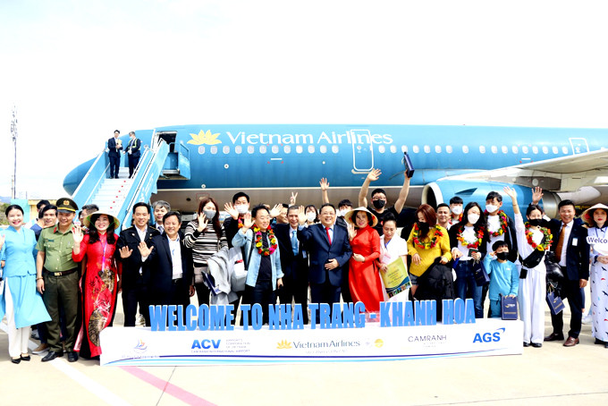 Đồng chí Lê Hữu Hoàng cùng các đại biểu chụp ảnh với du khách Hàn Quốc đến Khánh Hòa  trên chuyến bay của Vietnam Airlines sáng 1-1. 