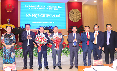 Các vị lãnh đạo tỉnh tặng hoa cho ông Trần Hòa Nam (thứ 5 từ phải sang) và ông Nguyễn Anh Tuấn (thứ 3 từ trái sang)