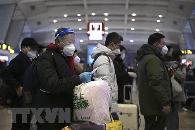 Hành khách xếp hàng chờ lên tàu tại nhà ga ở Bắc Kinh, Trung Quốc. (Ảnh: AFP/TTXVN)