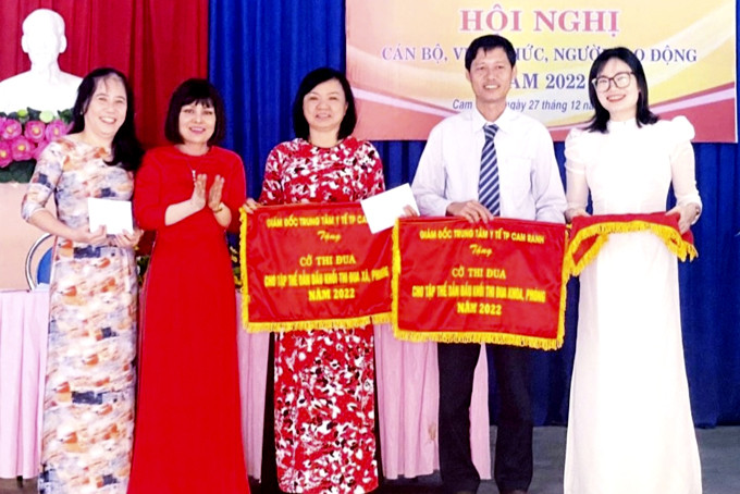 Bác sĩ Nguyễn Phi Vân (giữa) nhận cờ thi đua tập thể dẫn đầu khối thi đua  trạm y tế xã, phường năm 2022.