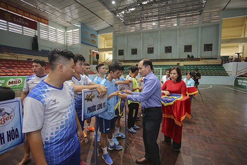 Nguyen Tuan Thanh, deputy director of Khanh Hoa Provincial Department of Culture and Sports, offering souvenir flags to teams
