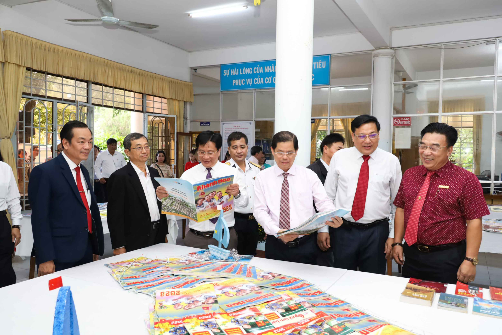 Ông Nguyễn Tấn Tuân cùng các đại biểu xem ấn phẩm giới thiệu tại Hội báo Xuân 2023. 