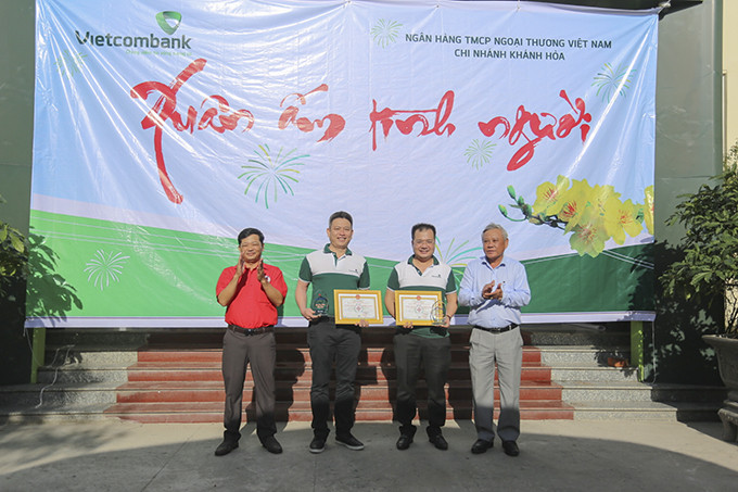 Ông Tống Trân-Bí thư Thị ủy Ninh Hòa, Chủ tịch HĐND thị xã trao biểu trưng tấm lòng vàng nhân đạo cho đại diện phía ngân hàng.