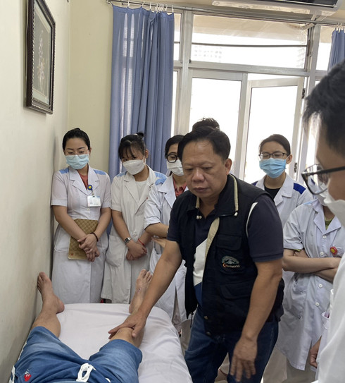 Bác sĩ Phan Vương Huy Đổng - Chủ tịch Liên  chi hội Hội Y học Thể dục thể thao TP. Hồ Chí Minh khám cho bệnh nhân tại Bệnh viện Đa khoa tỉnh.