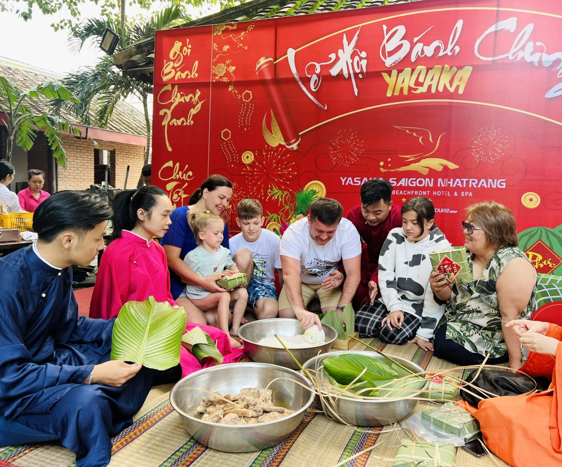 Một gia đình khách Nga thử gói bánh chưng với sự hướng dẫn của nhân viên khách sạn Yasaka-Siagon-Nhatrang