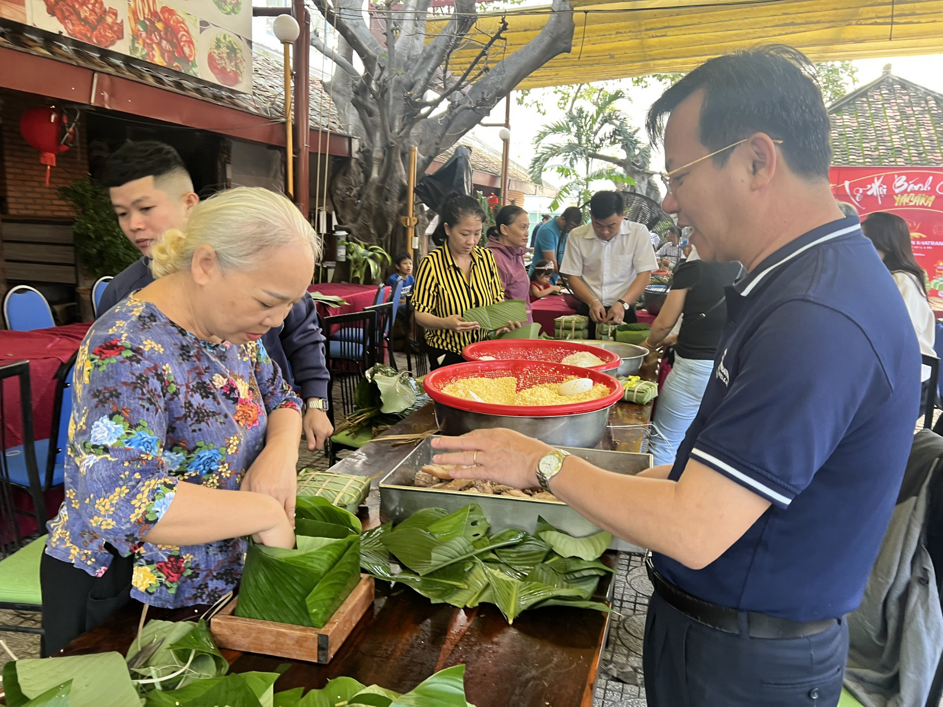 Tran Tan Ngoc, general director of Yasaka Saigon Nhatrang Joint Stock Company instructing Bich Thuy (70 years old, Phuoc Long Ward, Nha Trang) to wrap “banh chung”