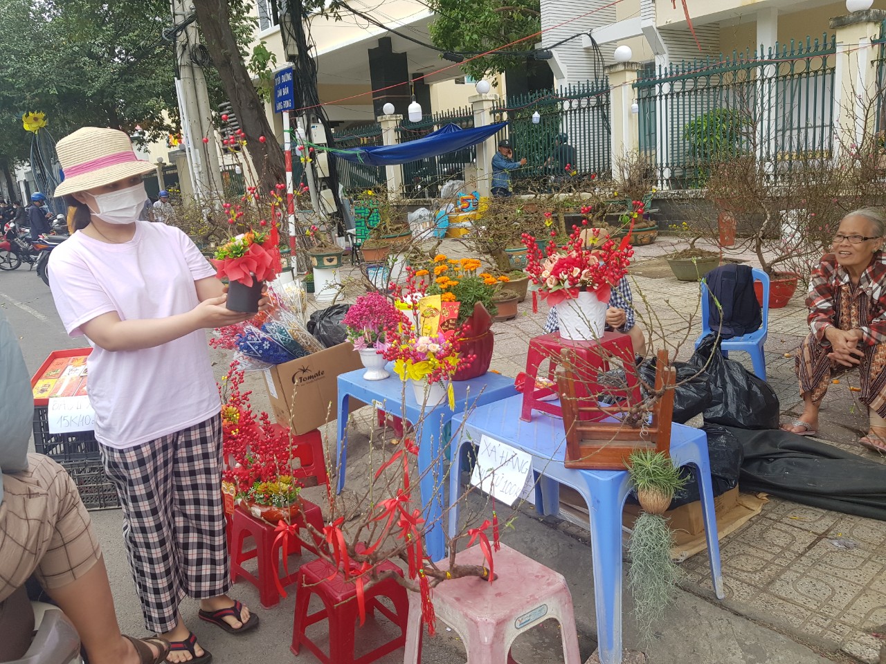 Các chậu hoa giả và cành đào nhỏ vẫn còn được bán trên đường Lê Thánh Tôn chiều 30 Tết.
