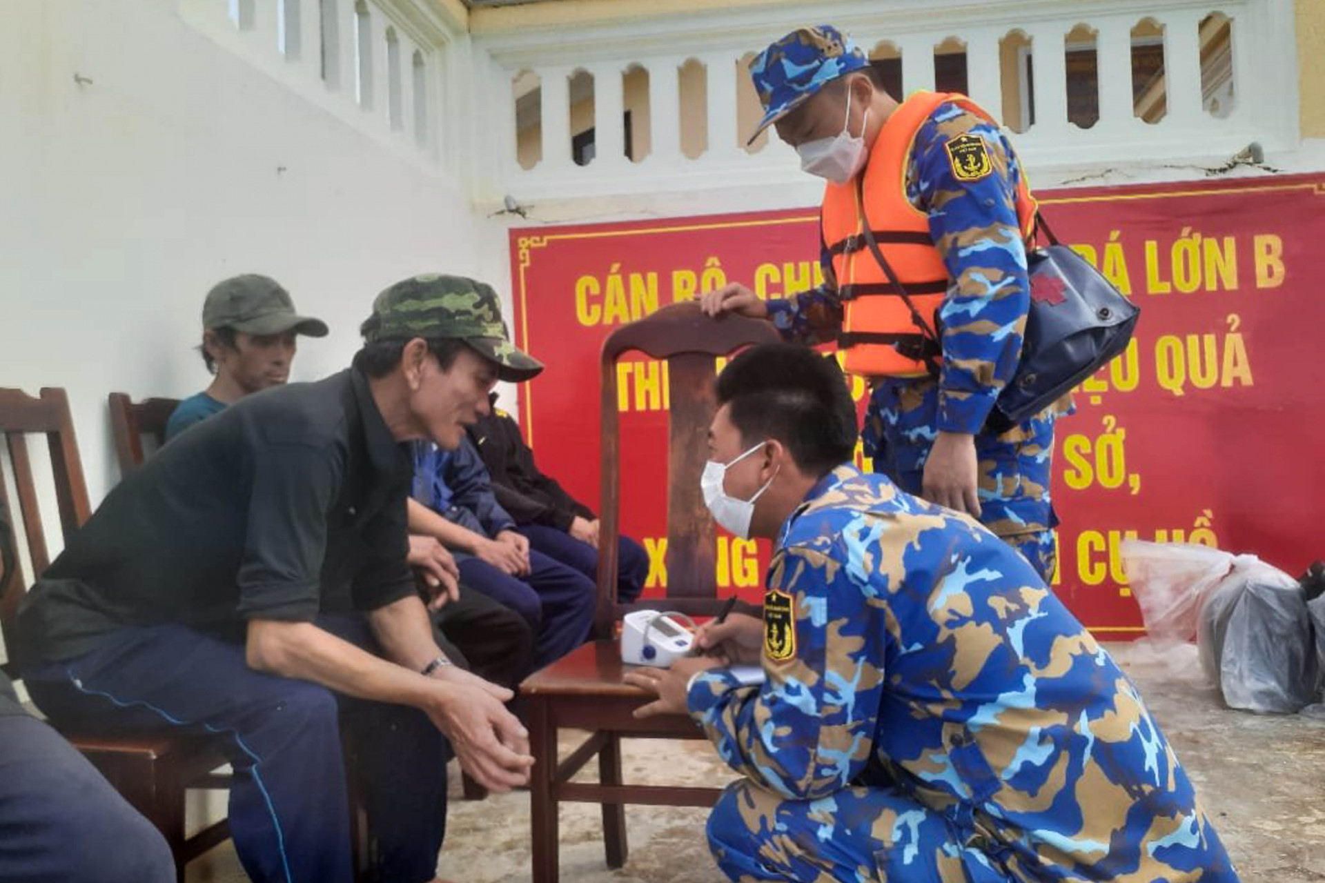 Cán bộ, chiến sĩ đảo Đá Lớn B hỗ trợ đưa ngư dân trên tàu cá PY 92396 TS lên đảo và thăm khám sức khoẻ cho ngư dân