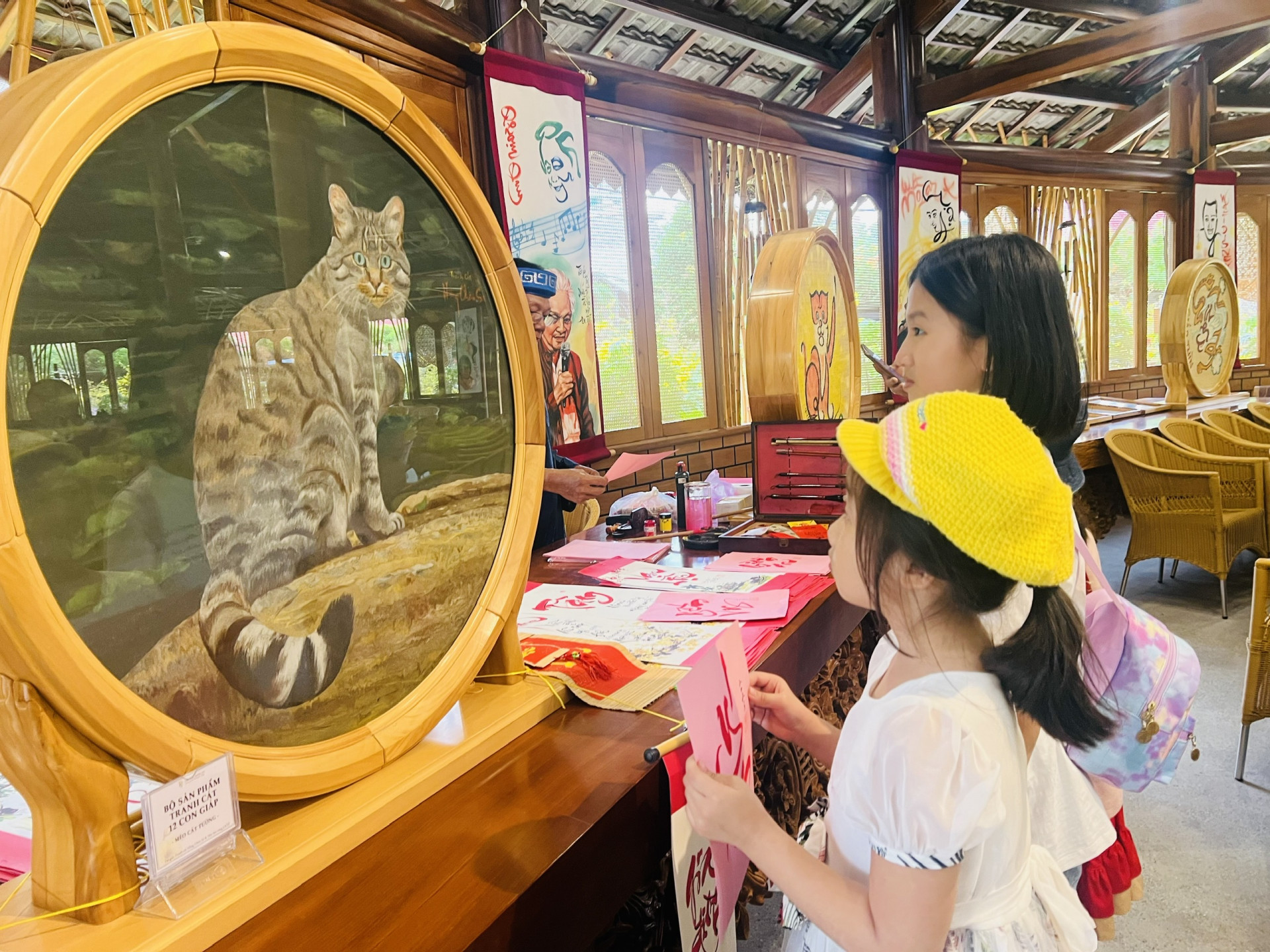 Children viewing painting of cat