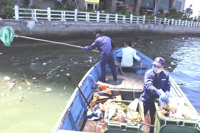 Công nhân  Công ty Cổ phần  Môi trường đô thị Nha Trang thu gom rác thải trên vịnh Nha Trang.