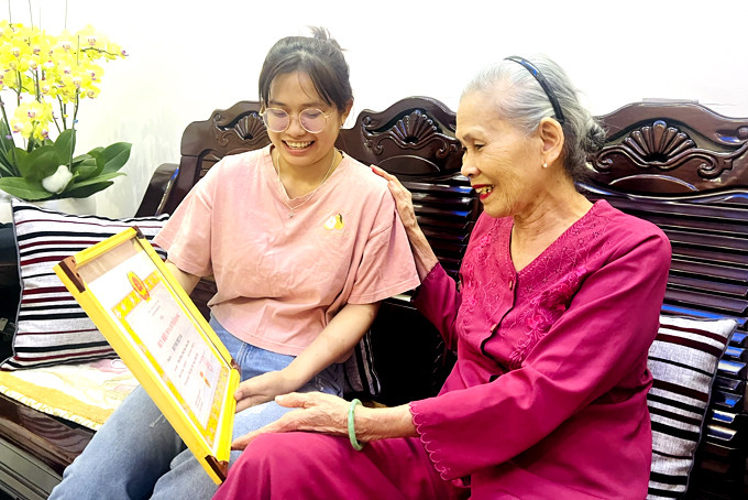 Bà Huỳnh Thị Tám kể chuyện với cháu gái về những năm tháng bị địch bắt, tù đày.