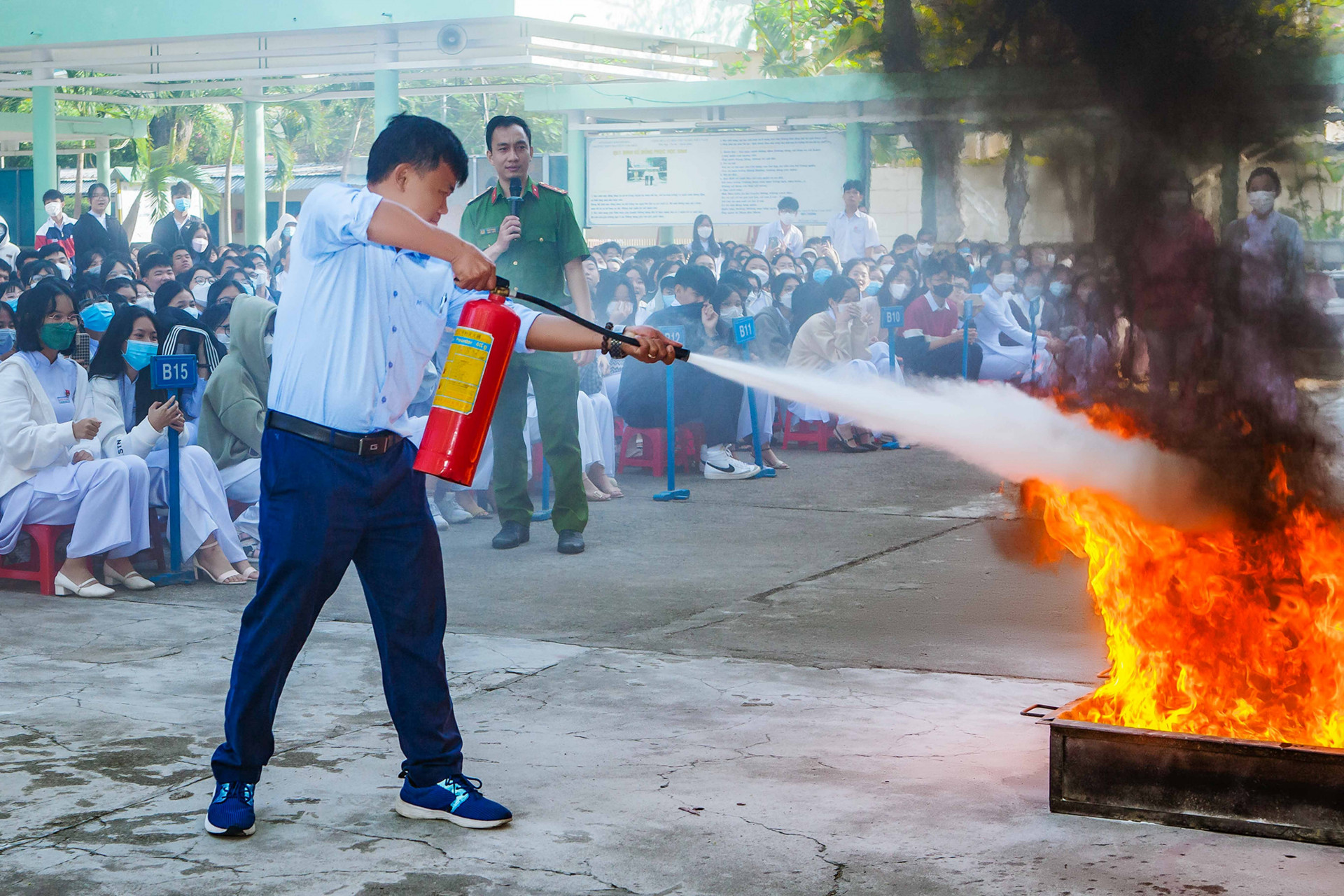 Các học sinh thực hành sử dụng bình chữa cháy dập tắt đám cháy