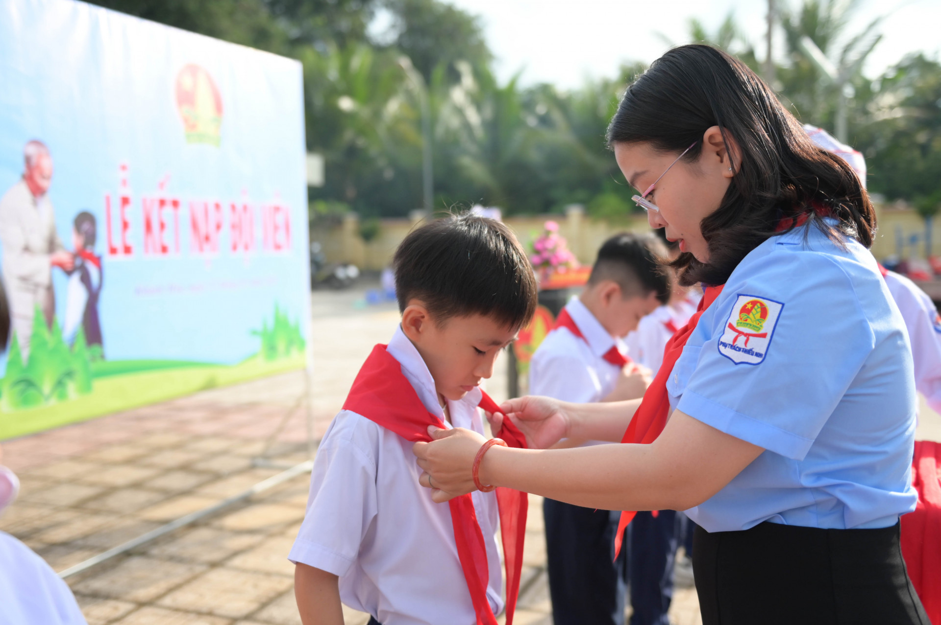 Chị Huỳnh Thị Như Ý - Phó Bí thư Tỉnh đoàn, Phó Chủ tịch Thường trực Hội đồng Đội tỉnh trao khăn quàng cho các nhi đồng