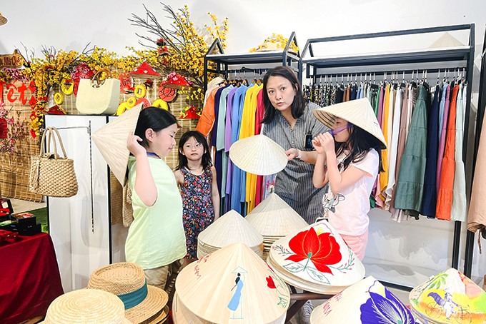 Khách du lịch Hàn Quốc mua nón lá khi du lịch ở Nha Trang.
