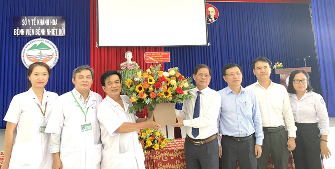 Ông Nguyễn Tấn Tuân tặng hoa chúc mừng cho đội ngũ y, bác sĩ Bệnh viện Bệnh nhiệt đới tỉnh.