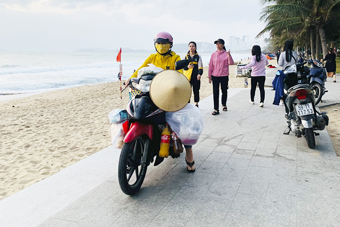 Bán hàng rong bằng xe máy trên công viên bờ biển
