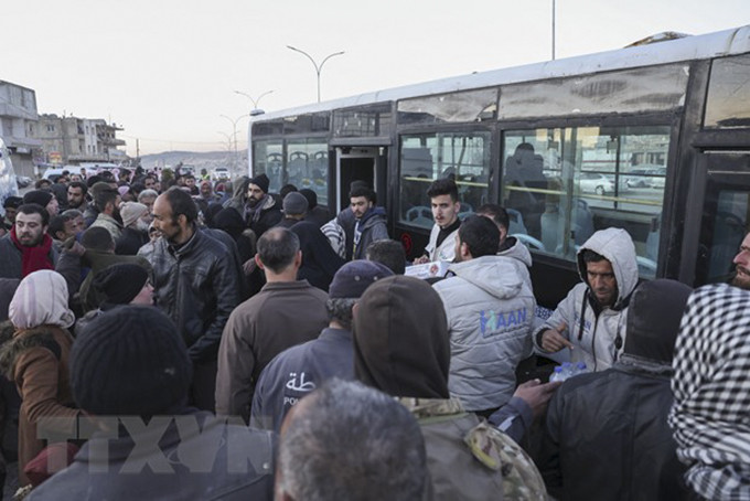 Người dân Syria lánh nạn ở Thổ Nhĩ Kỳ lên xe buýt để trở về nước tại cửa khẩu Bab al-Hawa, ngày 17/2/2023. (Ảnh: AFP/TTXVN)