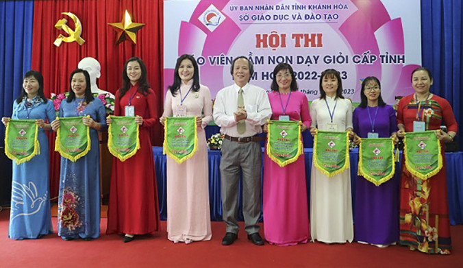 Ông Đỗ Hữu Quỳnh - Phó Giám đốc Sở Giáo dục và Đào tạo Khánh Hòa trao cờ lưu niệm cho các phòng giáo dục và đào tạo.