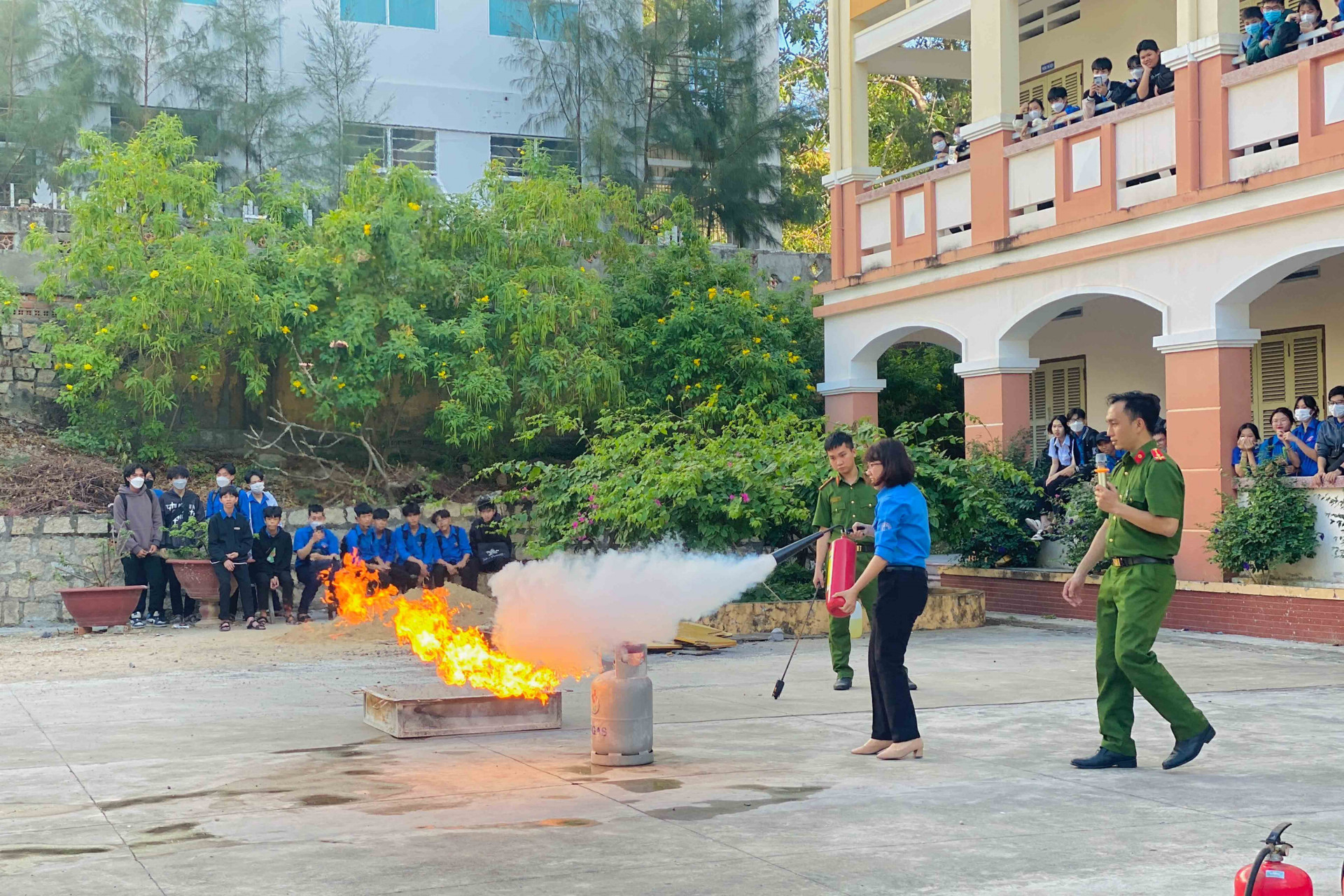 Các giáo viên, học sinh thực hành dập tắt đám cháy