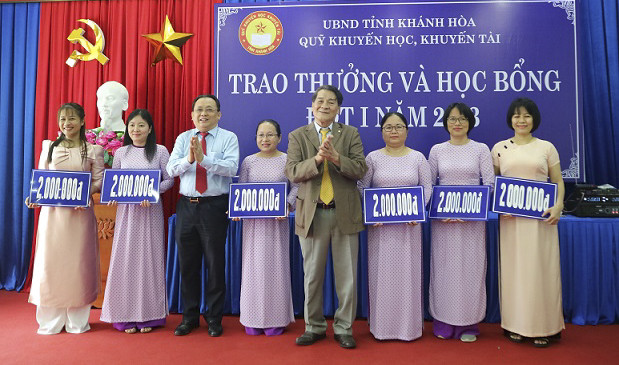 Ông Lê Hữu Hoàng và ông Phạm Văn Chi trao phần thưởng cho các giáo viên. 