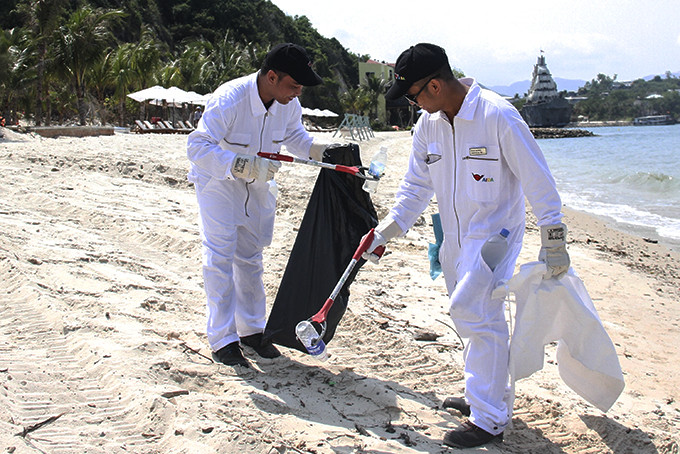 Khách du lịch nước ngoài nhặt rác tại biển Nha Trang.