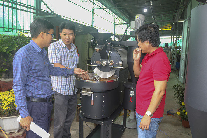 Anh Võ Quốc Thanh (thứ hai từ trái sang) giới thiệu về máy rang xay cà phê mới.