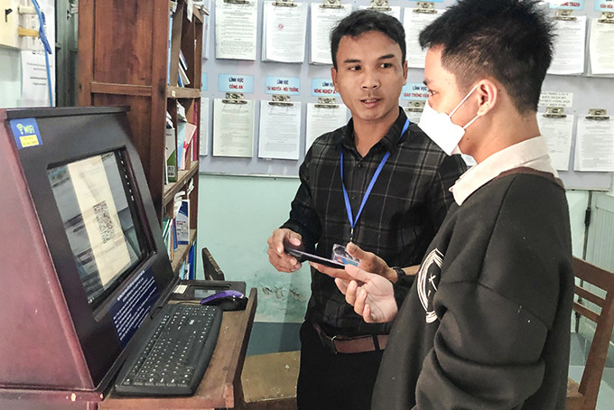 Công chức UBND xã Khánh Hiệp (Khánh Vĩnh) hướng dẫn người dân quét mã QR tra cứu thông tin thủ tục hành chính.