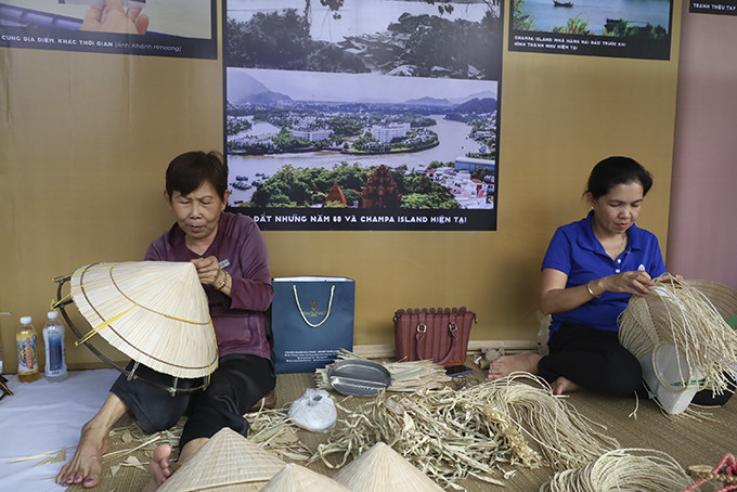 Bà Nguyễn Thị Lợi (bên trái) thực hiện thao tác làm nón tại không gian triển lãm Khánh Hòa - xưa và nay. 